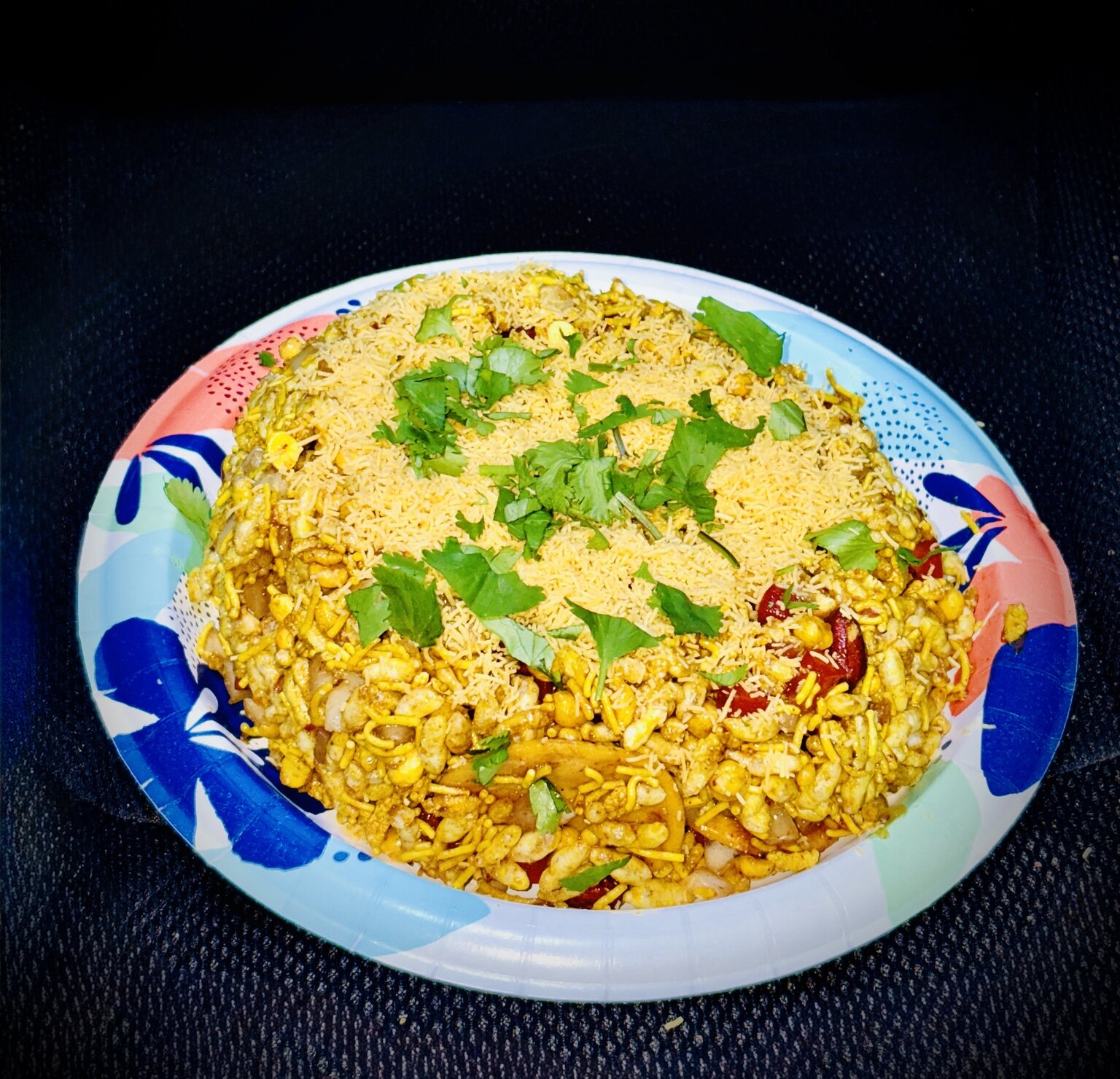 Bhel puri topped with sev and fresh cilantro