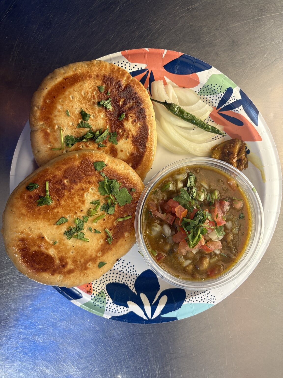 Kulche chole served with onions and fresh cilantro