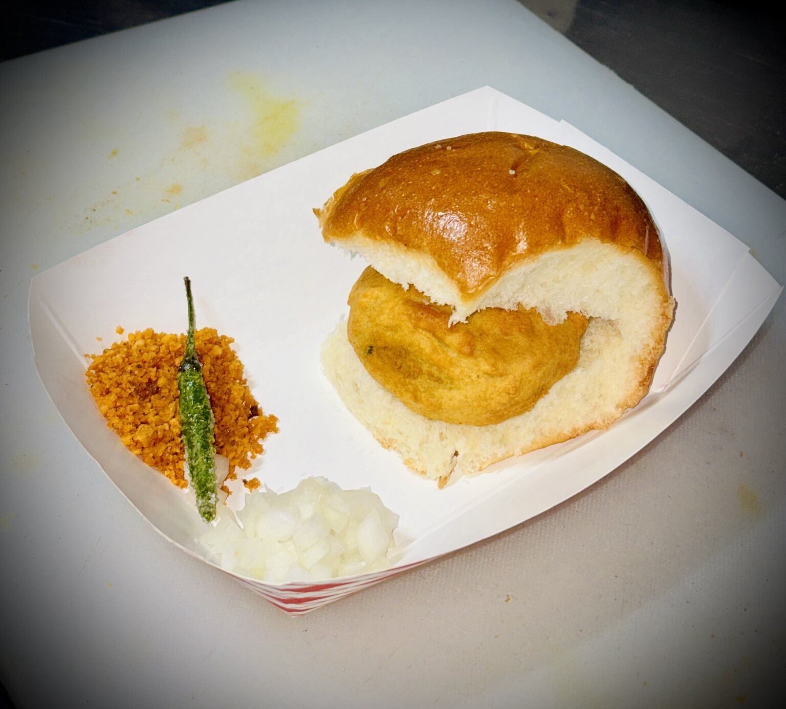 Fresh vada pav with dry chutney, green chili and onions
